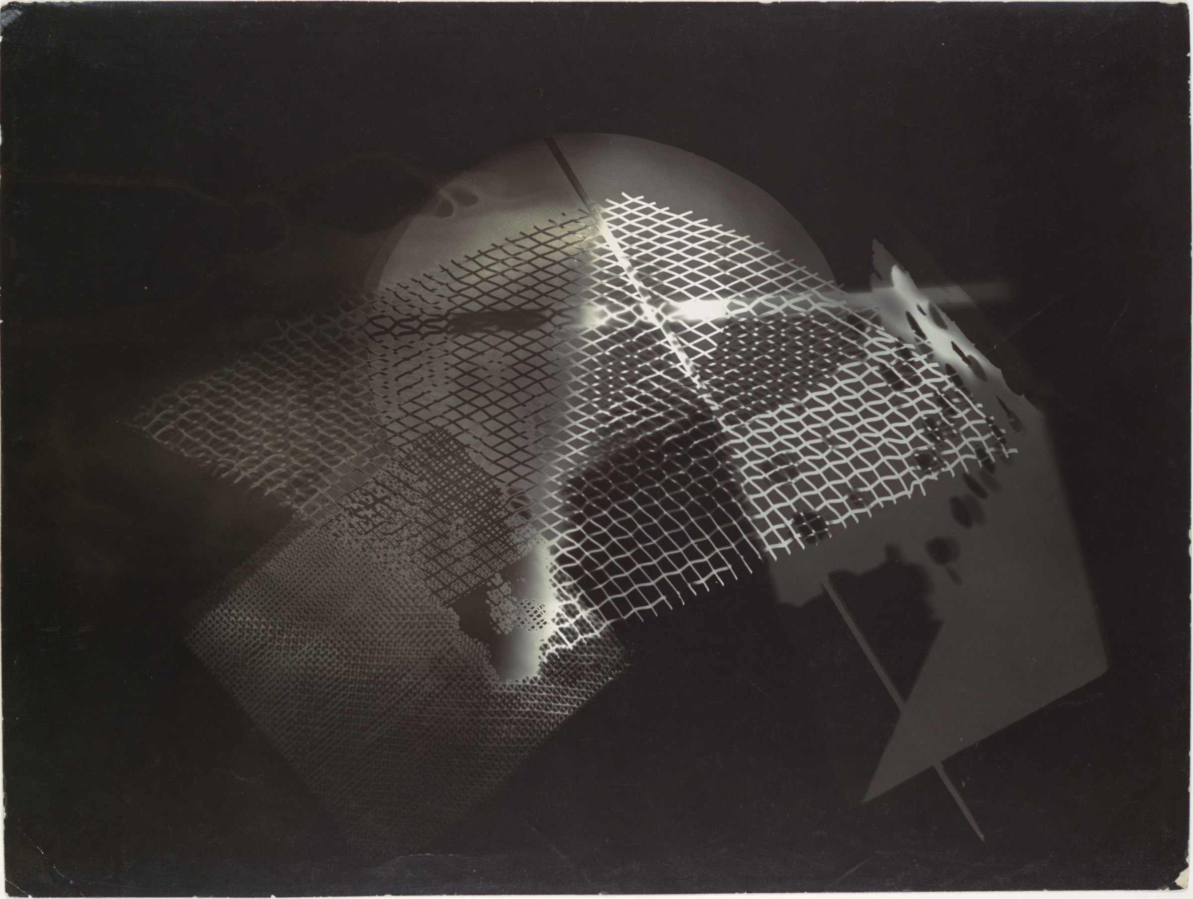 A black photogram of overlapping translucent shapes and a grid of light, made without a camera