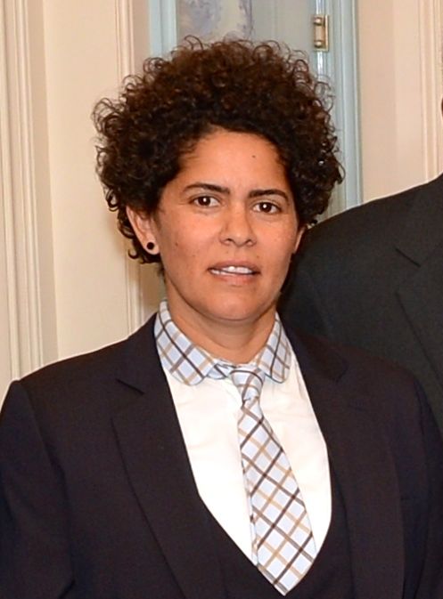 Julie Mehretu in a dark jacket, checked shirt and tie